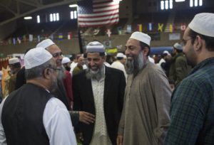 TEANECK, NJ - OCTOBER 26: Muslim-American men greet each other at the annual Eid al-Adha prayer held at the Teaneck Armory in Teaneck, New Jersey. Eid al-Adha, also known as the Feast of the Sacrifice, commemorates Abraham's willingness to sacrifice his son as an act of obedience to God, who in accordance with tradition then provided a lamb in the boy's place. (Photo by Robert Nickelsberg/Getty Images)